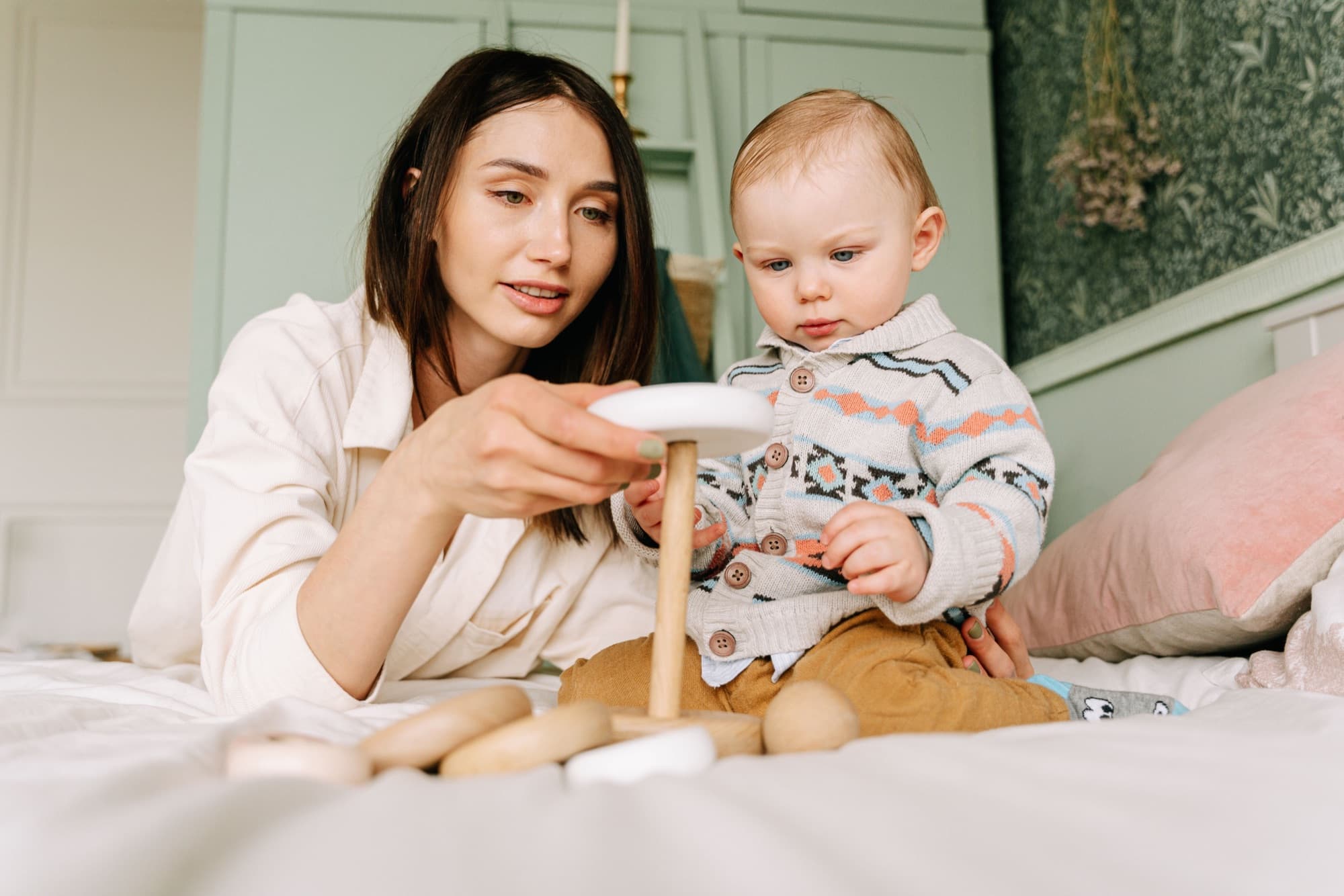 A mother playing with her toddler at home