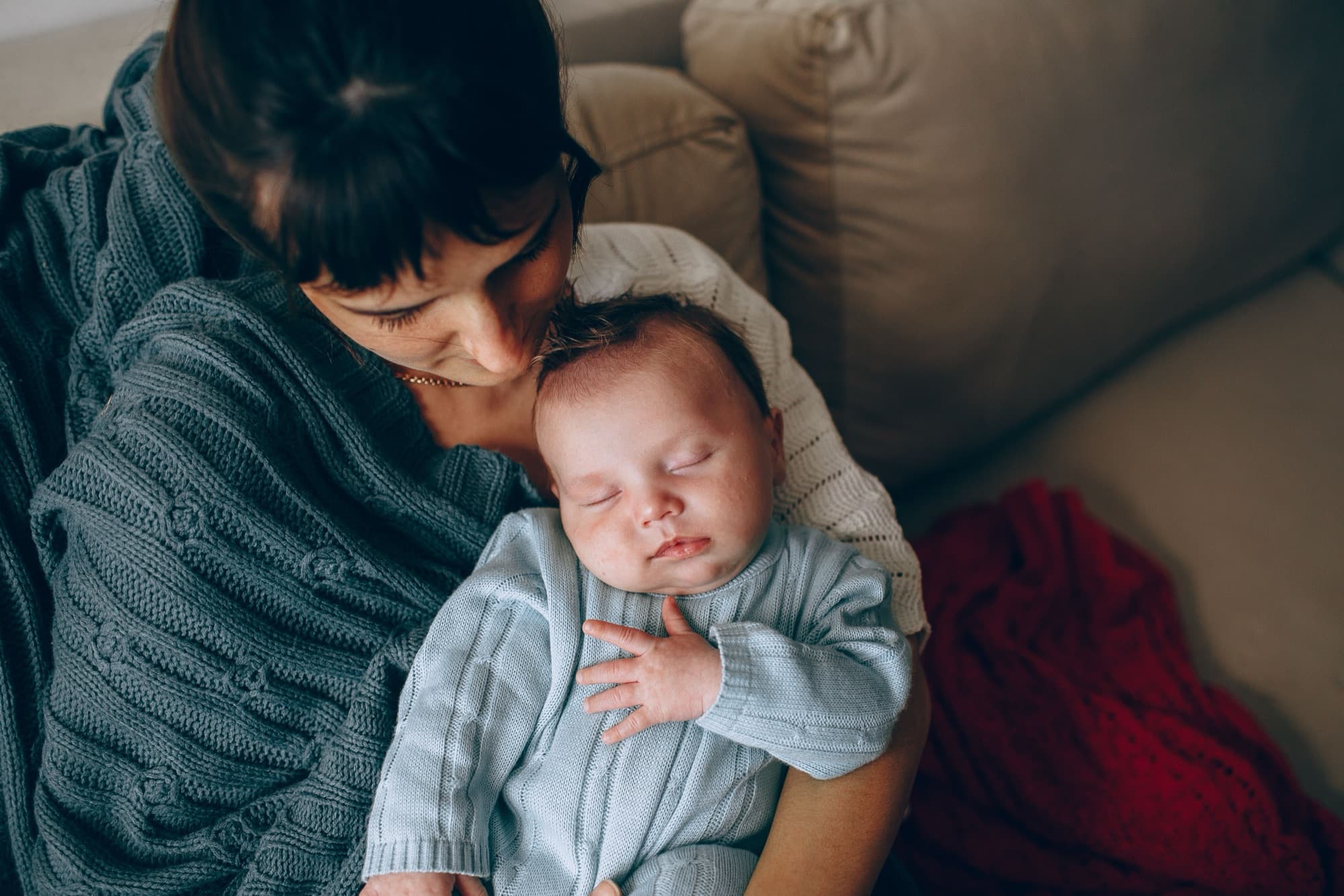 A mother cradling her sleeping newborn